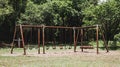 Rustic swings, empty playground, forest backdrop, summer day Royalty Free Stock Photo