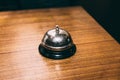 Rustic table bell or call bell on wooden table. For calling waiter