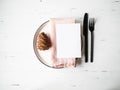 Rustic table with Christmas setting with plate, pink napkin, menu card and appliances on white wood table. Top view Royalty Free Stock Photo