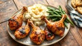 A rustic table with a platter of grilled chicken drumsticks mashed potatoes and green beans