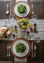 A rustic table setting features a dark wooden table adorned with a white cloth runner. Royalty Free Stock Photo