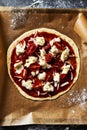 Rustic thin crust pizza with cherry tomatoes and mozzarella being made. Homemade