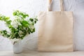 Rustic tote bag mockup with flowering apple tree branch