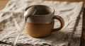 Rustic Two-Tone Ceramic Mug with Spoon on Linen Cloth Royalty Free Stock Photo