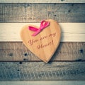 Rustic Valentine`s Day Wooden Heart with Pink Bow and message You Are My Heart written on it.  It`s on a gray and white distress Royalty Free Stock Photo