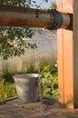 Rustic view: a metal bucket on a chain stands on a wooden well