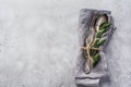 Rustic Vintage Set Of Cutlery. Plate With Grey Linen Napkin, Fork And Spoon, Olive Tree Branch Over Rustic Concrete Gray Old