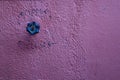 Rustic violet plaster on distressed wall, photo texture. Faucet valve on textured wall background