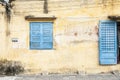 Rustic wall with blue door and window. Royalty Free Stock Photo