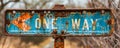 Rustic and weathered One Way sign with a directional arrow, on a rusty post, indicating a single direction against a clear Royalty Free Stock Photo