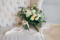 Rustic wedding bouquet with creamy roses and white carnations on a luxury cream sofa. Close-up. Side view Royalty Free Stock Photo