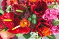 Rustic wedding bouquet with orange, crimson and bordeaux roses, poppy and other flowers and greens on wooden background Royalty Free Stock Photo