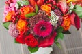 Rustic wedding bouquet with orange, crimson and bordeaux roses, poppy and other flowers and greens on wooden background Royalty Free Stock Photo