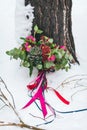 Rustic wedding bouquet with succulents and crimson flowers on the snow next to the tree. Outdoors. Artwork Royalty Free Stock Photo