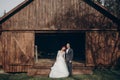 Rustic wedding couple posing and standing at background of wooden barn. wedding concept, space for text. happy stylish bride and Royalty Free Stock Photo