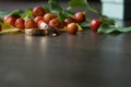 Rustic wedding decorations. Red small apples and gold rings on a wooden background with a blurry foreground with a place for an Royalty Free Stock Photo