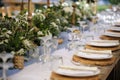 Rustic wedding table details with flowers and white linen. Royalty Free Stock Photo