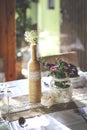 Rustic wedding table set with glass bottle and bouquet Royalty Free Stock Photo