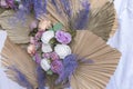 A rustic wedding wall decor made of dried palm spears,lavenders, and white, pastel orange and purple florals