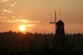 Rustic windmill in the rural field at a bright sunset Royalty Free Stock Photo
