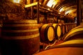 Rustic wine storage room with wooden barrels.