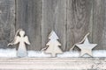 Rustic winter background with wooden figures star, Christmas tree and angel with snow on wooden texture. Christmas and New Year Royalty Free Stock Photo