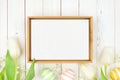 Rustic wood frame with Easter eggs and white spring tulip flowers against a white wood background Royalty Free Stock Photo