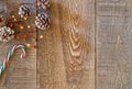 Rustic wood plank background with white tipped pine cones, berries and holiday candy cane on top left corner Royalty Free Stock Photo
