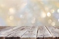 Rustic wood table in front of glitter silver and gold bright bokeh lights