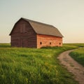 A rustic, wooden barn with a dark gable roof stands in an open grassy field. The barn Royalty Free Stock Photo