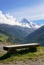 Rustic wooden bench overlooking Swiss Alps.