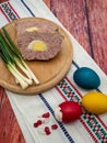 Rustic wooden board with a freshly prepared pate and colorful boiled eggs
