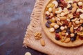 Rustic wooden bowl with assorted nuts, raisins and cranberries on sacking background. Hazelnuts , Walnuts, almonds Royalty Free Stock Photo