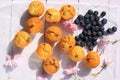 Rustic wooden breakfast background with bluberries, fresh muffins and blooming cherry flowers Royalty Free Stock Photo