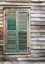 Rustic wooden building window with closed green shutters