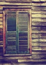 Rustic wooden building window with closed green shutters