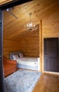 Rustic wooden cabin interior with bed, sofa, and armoire