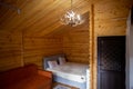 Rustic wooden cabin interior with bed, sofa, and armoire