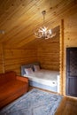 Rustic wooden cabin interior with bed, sofa, and armoire