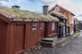 Rustic wooden cabins with turf roofs in Roros lead the eye down a gravel path, showcasing the heritage of this Norwegian Royalty Free Stock Photo