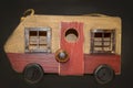 Rustic wooden camper van pull toy with rusty windows against dark brown background Royalty Free Stock Photo