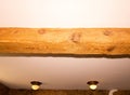 Rustic wooden ceiling beam with recessed lights in cozy room interior Royalty Free Stock Photo