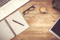 Rustic wooden desk with laptop, notebook, pen, glasses, coffee cup and tablet computer. Modern workspace with copy space. Filter Royalty Free Stock Photo