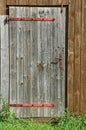 a door to a small barn on the edge of the green grass