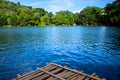 Rustic wooden raft on still water lake. Idyllic lake crossing with old raft. Royalty Free Stock Photo