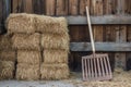 A rustic wooden rake leaning against a stack of fresh hay bales Royalty Free Stock Photo