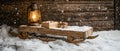 A RUSTIC WOODEN SLED COVERED IN SNOW, A LANTERN, AND A SMALL BOX OF SWEETS, SET AGAINST A WOODEN BACKGROUND Royalty Free Stock Photo