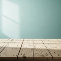 Sunlit wooden tabletop with soft light casting shadows against a calming pastel green wall background Royalty Free Stock Photo
