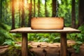 Wood table with hanging wooden sign on green forest blurred background.