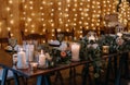 Rustic wooden table adorned with white candles and an arrangement of vibrant orange and white roses Royalty Free Stock Photo